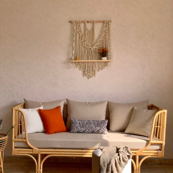 SEDRA rattan daybed sofa with beige mattress cushion under a macrame wall hanging