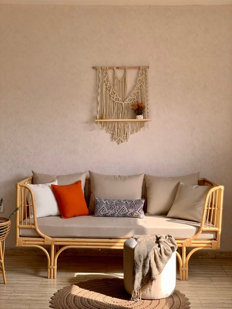 SEDRA rattan daybed sofa with beige mattress cushion under a macrame wall hanging